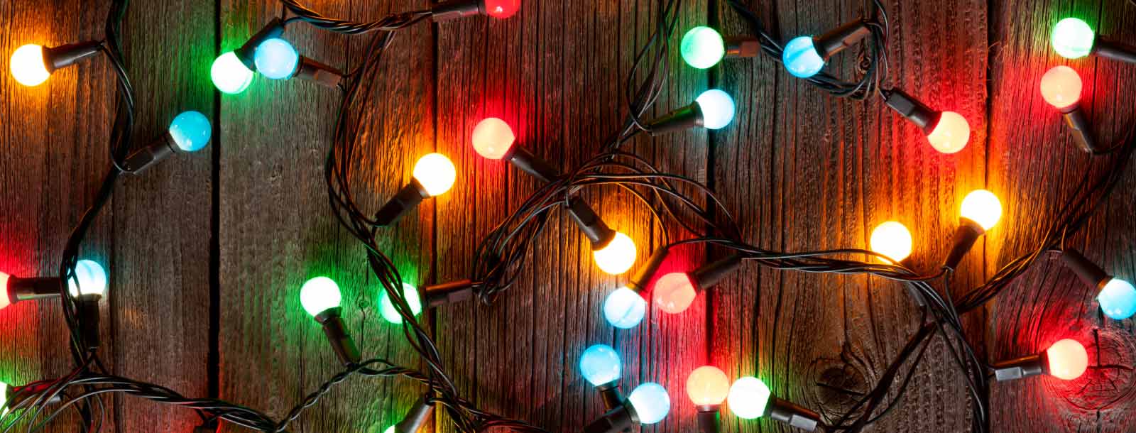 Colorful string lights on a wooden background